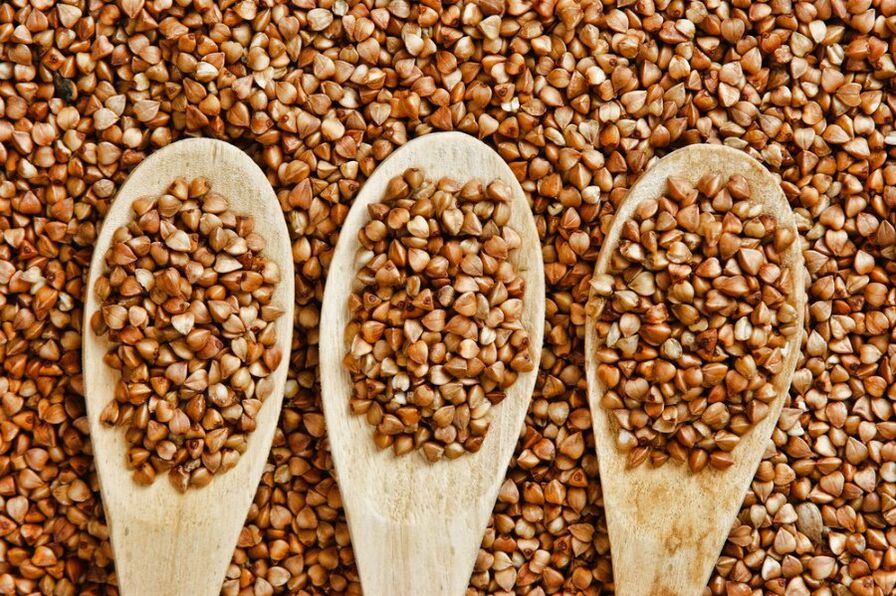 Buckwheat grain in wooden spoons